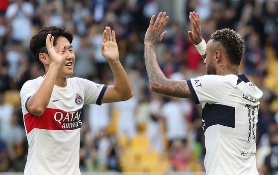 Lee Kang-in, left, congratulates Neymar after the Brazilian forward scored Paris Saint-Germain's second goal in a game against Jeonbuk Hyundai Motors at Busan Asiad Main Stadium in Busan on Thursday.  [NEWS1]