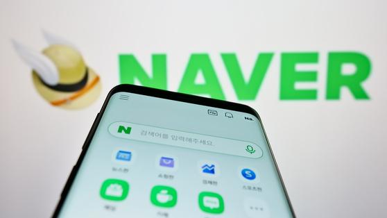 A person holding a cellphone with the Naver logo on screen. [SHUTTERSTOCK]