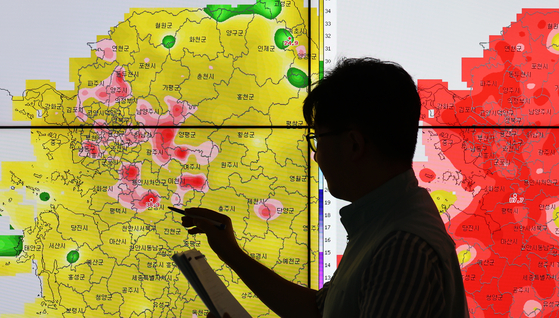 A weather analyst checks nationwide temperatures at the Seoul Metropolitan Office of Meteorology in Suwon, Gyeonggi, on Sunday as temperatures hover near 35 degrees Celsius (95 degrees Fahrenheit). [YONHAP]