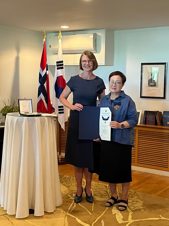 Ambassador of Norway to Korea Anne Kari H. Ovind, left, presents Kim Miy-He, professor emeritus at the Theatre and Film Department of Hanyang University, the Royal Norwegian Order of Merit for her work translating Henrik Ibsen’s plays at Norway's diplomatic residence in Seoul on Thursday. Kim has been appointed Commander of the Royal Norwegian Order of Merit by His Majesty King Harald V of Norway for her work translating all of Henrik Ibsen’s plays and for her contribution to making Henrik Ibsen and his plays known in Korea, according to the Norwegian Embassy in Seoul. [EMBASSY OF NORWAY IN KOREA]