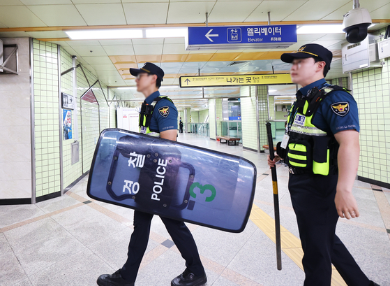 Police in gears patrols Ori Station in Seongnam, Gyeonggi, on Friday. Ori is one of the subway stations that was given warnings of an attack much similar to the one two weeks ago and on Thursday. [YONHAP]