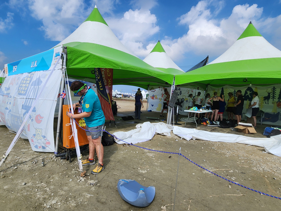 A British scout who took part in the 25th World Scout Jamboree at Saemangeum in Buan County, North Jeolla, is seen disassembling the country’s promotional booth within the event site on Saturday, following the UK Scout’s announcement of their withdrawl from the Jamboree. [YONHAP]