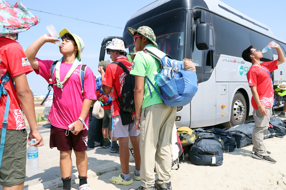 U.S. scouts drink water as they prepare to leave the Jamboree campsite in Buan County, North Jeolla, on Sunday. [YONHAP]