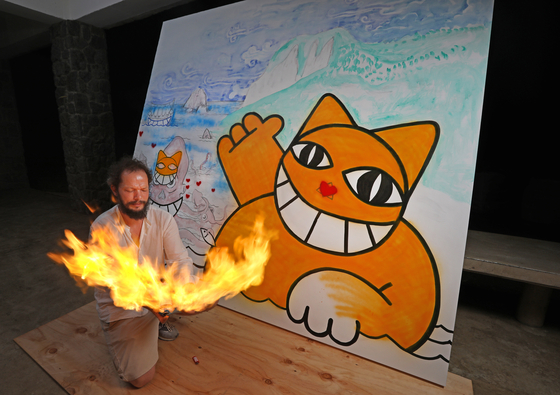 Thoma Vuille does a fire performance while painting M.Chat against a backdrop of local scenery at Stay Neowa, a lodging on Ulleung Island, North Gyeongsang. [PARK SANG-MOON]