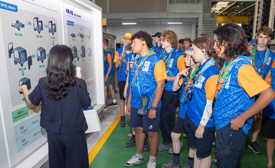 Scouts participating in the World Scout Jamboree tour Hyundai Motor's truck manufacturing line at its plant in Jeonju, North Jeolla, on Monday. [HYUNDAI MOTOR]