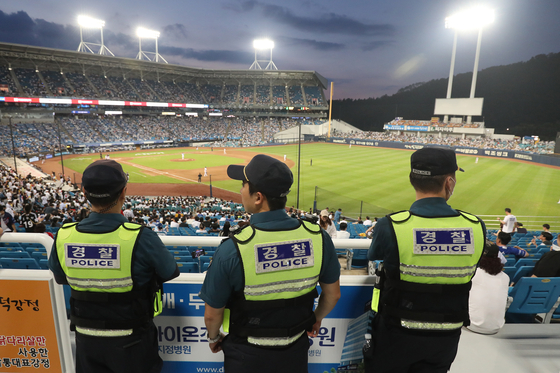 Police watch the crowd during a game between the Samsung Lions and LG Twins at Daegu Samsung Lions Park in Daegu on Sunday after an anonymous threat was posted online.  [NEWS1]