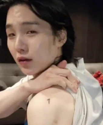 A livestream image of BTS Suga showing off his tattoo on Sunday. [SCREEN CAPTURE]
