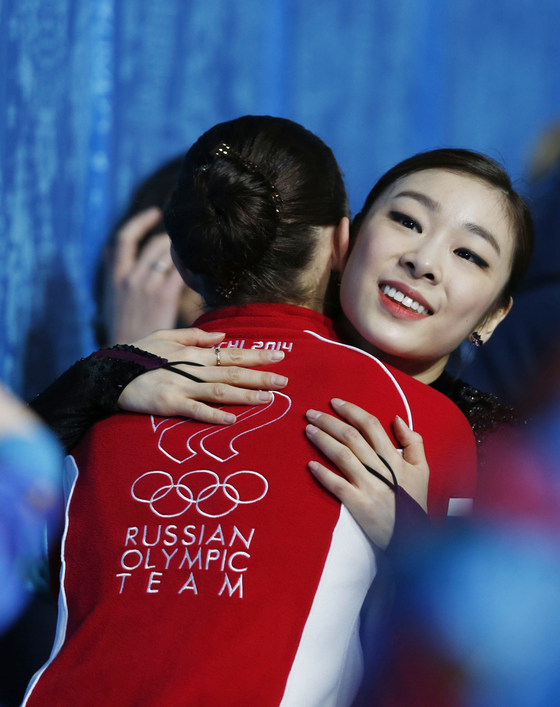 Silver medalist Kim Yuna of Korea, right, hugs gold medalist Adelina Sotnikova of Russia after the ladies' figure skating free skating event at the 2014 Sochi Winter Olympic Games in Sochi, Russia on Feb. 20, 2014.  [XINHUA/YONHAP]