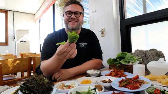 Givens pose with ssam (food wrapped in lettuce or weed) at a local restaurant in Korea. [AUSTIN GIVENS]