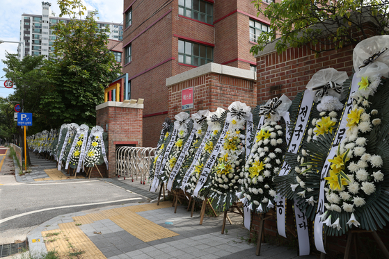 Memorial wreath placed in front of the Uijeongbu Howon Elementary School in Gyeonggi on Wednesday where two teachers took their own lives in 2021 just six months apart. The school reported the death simply as accidents. [YONHAP] 
