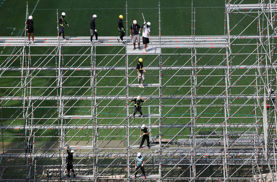Workers prepare the Seoul World Cup Stadium in western Seoul for the upcoming ″K-pop Super Live″ concert set for Friday to close the 25th World Scout Jamboree. Eighteen K-pop acts will perform for two hours starting at 7 p.m. on Friday. [YONHAP]