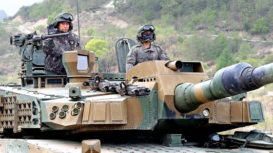Ambassador of Myanmar to Korea Thant Sin, left, on a K-2 tank during a Korean arms promotional event in Pocheon, Gyeonggi, on May 2. [NEWS1] 