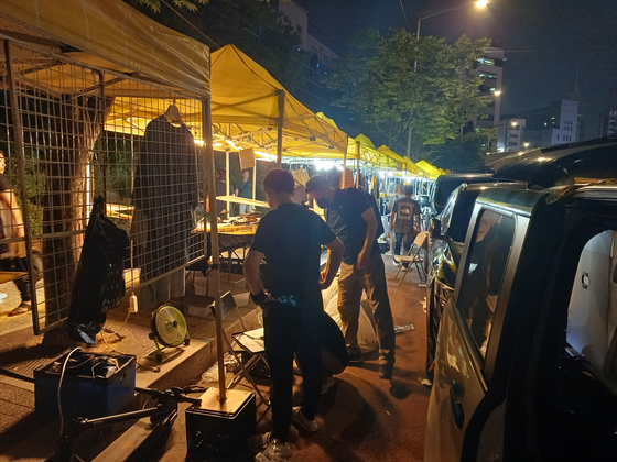 Trademark police officers from the Korean Intellectual Property Office (KIPO) bust a stall selling fake brands at Dongdaemun Sebit Market in Jung District, central Seoul. KIPO announced Wednesday that it confiscated 1,230 imitation items and booked six dealers who sold them. [YONHAP]