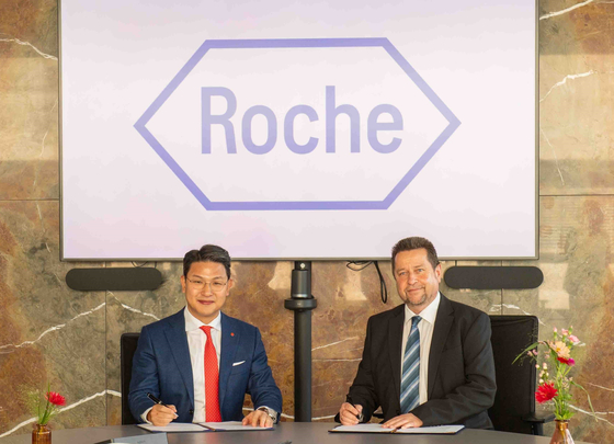 Richard Lee, left, Lotte Biologics CEO, and Rainer Mueller, vice president of Roche CustomBiotech, pose for a photo during an agreement signing ceremony held in Penzberg, Germany. [LOTTE BIOLOGICS]