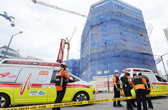 First responders at the scene of the nine-story building that is being constructed in Anseong, Gyeonggi, on Wednesday where one of the floor collapsed, killing two workers. [YONHAP]