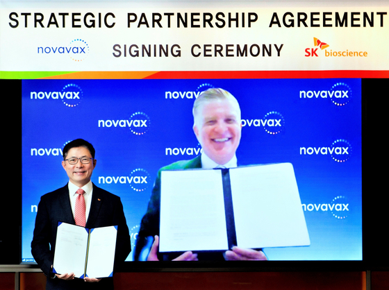 SK bioscience CEO Ahn Jae-yong, left, and John C. Jacobs, Novavax CEO, on screen, pose for a photo during a virtual signing ceremony for an $84.5 million stock acquisition agreement. [SK BIOSCIENCE]