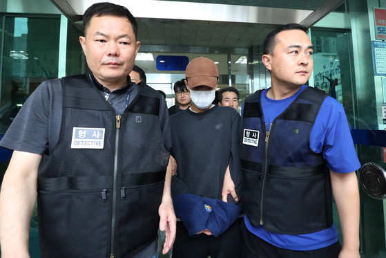 A man arrested for carrying a knife at Dongdaegu Station in Daegu earlier this week leaves a district court escorted by police on Wednesday after questioning. [NEWS1] 