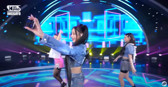 Minji of NewJeans is holding an iPhone 14 Pro during Inkigayo on July 30. [SCREEN CAPTURE]