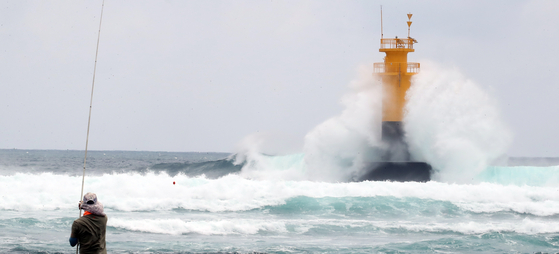 A man watches high waves from Seogwipo, Jeju Island, on Tuesday. The government raised alerts to the highest level as Typhoon Khanun is expected to make landfall on Korea’s southern coast Thursday. [NEWS1]