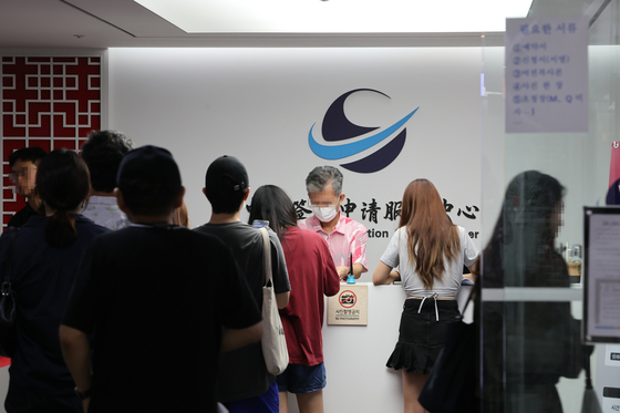 Visitors queue at a Chinese visa service center in downtown Seoul on Thursday. The visa requirements for short-term Korean travelers to China were to be simplified starting Friday. [YONHAP]