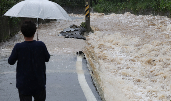 A road leading to a village in Daegu is submerged by a flood caused by Typhoon Khanun on Thursday. [YONHAP]