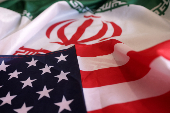 U.S. and Iranian flags. The countries have reached an agreement to free Americans for jailed Iranians and access to frozen funds in Korea. [REUTERS/YONHAP]