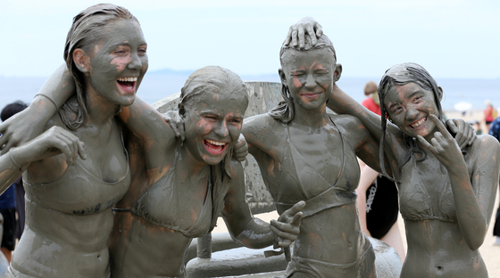 Participants of the 25th World Scout Jamboree participate in a mud festival organized for them at Daecheon Beach in Boryeong, South Chungcheong, on Wednesday. [NEWS1]