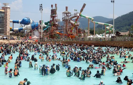 People play in the water at Lotte Water Park in Gimhae, South Gyeongsang on Sunday amid a continued heat wave. [YONHAP] 