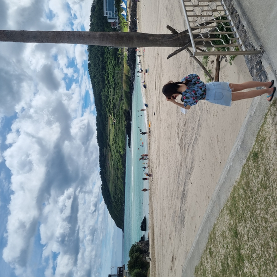 A tourist takes a picture of the scenery at Hamdeok Beach, Jeju City, Jeju. [KIM DONG-EUN]