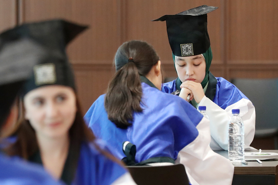 International students participate in the Sunkyun Hangeul Essay Contest at Sunkyunkwan University in Seoul on Aug. 9, wearing traditional Korean Confucian scholar attire. Winners of the annual Korean language essay competition are granted scholarships. [NEWS1] 
