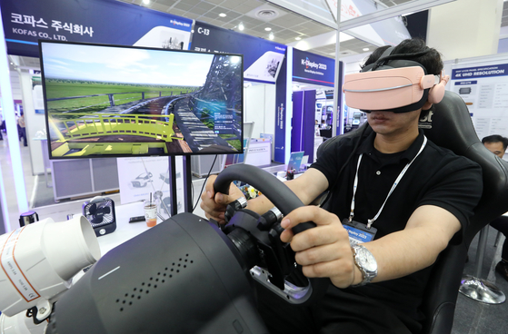 A visitor tries out a virtual reality device at K-Display 2023 where the latest technology from the display industry is being showcased. The exhibition runs at Coex in southern Seoul through Friday. [NEWS1]