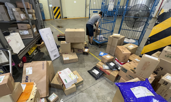 A courier sorts parcels at a logistics center in Seoul on Wednesday after the annual “no parcel day,” a movement designed to give couriers a day off. This year, couriers got three consecutive days off as the annual holiday fell on Monday between Sunday and Liberation Day on Tuesday. [NEWS1]