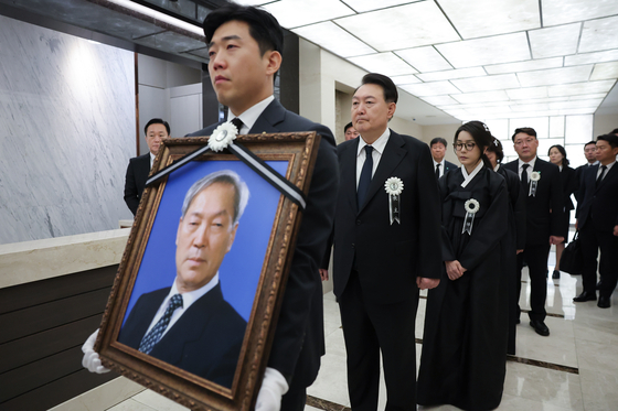 President Yoon Suk Yeol, second from left, and first lady Kim Keon-hee, third from left, walk behind a portrait of the president’s late father, Yoon Ki-jung, during a funeral procession at Severance Hospital in Seodaemun District, western Seoul, Thursday morning. The late Yonsei University professor was later buried in a cemetery in Gyeonggi. [PRESIDENTIAL OFFICE]