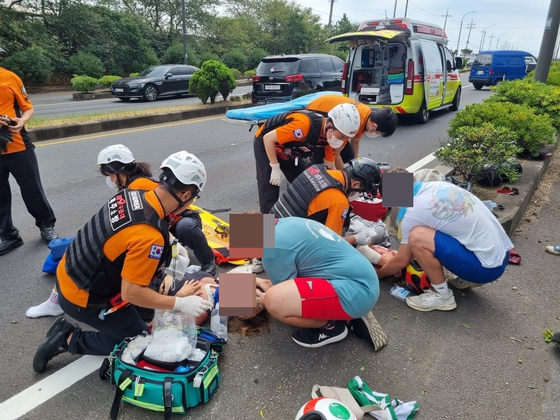 Emergency respondents attends to German teenagers aged 18 that were in a motorcycle accident along Daejeong-eup, Seogwipo in Jeju on Thursday. [JEJU FIRE SAFTEY HEADQUARTERS]
