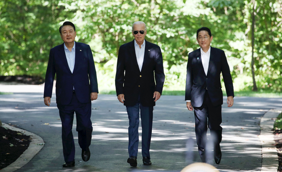 From left, Korean President Yoon Suk Yeol, U.S. President Joe Biden and Japanese Prime Minister Fumio Kishida take a walk together at Camp David in Maryland on Friday. [JOINT PRESS CORPS]