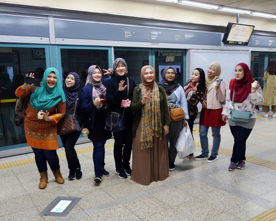 Foreign visitors pose for a photo at the platform of Itaewon Station in central Seoul. [SEOUL METRO]