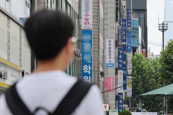A student walks by private academies in Daechi-dong, southern Seoul, on July 2. [YONHAP]