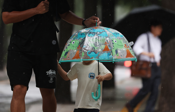 A child uses an umbrella on Aug. 10 in Seoul amid the rain. [YONHAP]