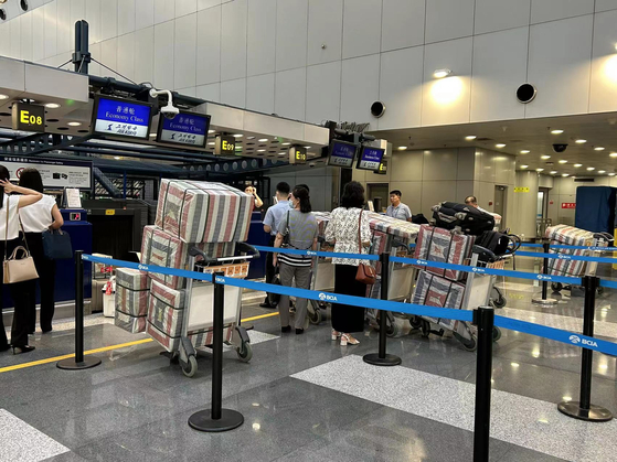 Passengers check in luggage for Air Koryo, North Korea's state-owned airline, at the check-in counter at Beijing Capital International Airport on Tuesday. [YONHAP] 