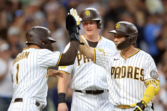 Trent Grisham, left, and Garrett Cooper, center, congratulate Kim Ha-seong of the San Diego Padres after he hit a grand slam during the second inning of a game against the Miami Marlins at Petco Park in San Diego on Monday. Kim went two-for-four in the game with two runs and four RBIs as the Padres beat the Marlins 6-2.  [AFP/YONHAP]