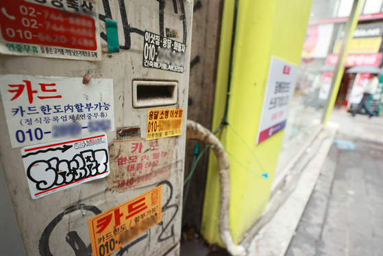 Stickers advertising credit card loans are posted in a street in Seoul on Tuesday as household debt-related risks grow. Loans on credit cards by Shinhan, Samsung, KB Kookmin, Hyundai, Lotte, Woori, Hana and BC Card totaled 35.4 trillion won ($26.4 billion) at the end of July, up 548 billion won, or 1.6 percent, from the previous month, according to the Credit Finance Association. [YONHAP]