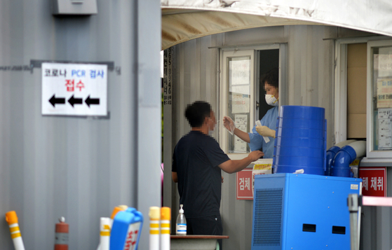 A person tests for Covid-19 at a testing center in Daejeon on Wednesday. The government said the status of Covid-19 will be lowered to that of the flu starting next Thursday. [KIM SEONG-TAE] 