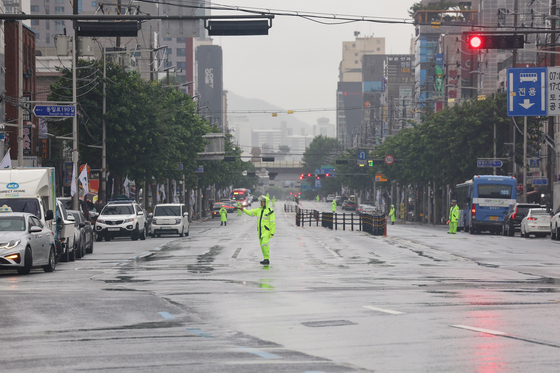 A police officer near Gongneung Station in Nowon District restricting cars and buses from moving after the civil defense exercise siren went off on Wednsesday. [YONHAP]