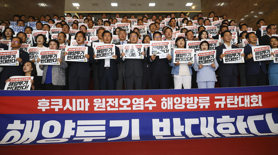 Members of the liberal Democratic Party host a rally at the National Assembly in Seoul on Tuesday to protest the Japanese decision to start releasing the treated radioactive water from Fukushima into the sea starting this Thursday. [KIM HYUN-DONG] 
