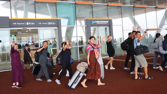 Chinese tourists arrive at the Incheon Port International Passenger Terminal on Wednesday. These tourists had embarked on the Huadong Ferry from Shidao, China, the day before. [YONHAP]