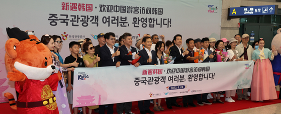 Chinese group tourists and officials of the Korea Tourism Organization (KTO) at Incheon International Airport on Thursday. The KTO held a welcoming ceremony for Chinese tourists who have returned after a six-year hiatus. [NEWS1]