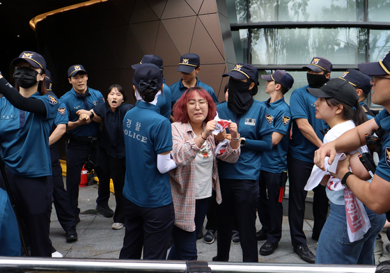 Police apprehend university students who attempted to break into the Japanese Embassy in central Seoul to protest the release of treated radioactive water from the ruined Fukushima Daiichi nuclear power plant on Thursday. [YONHAP] 