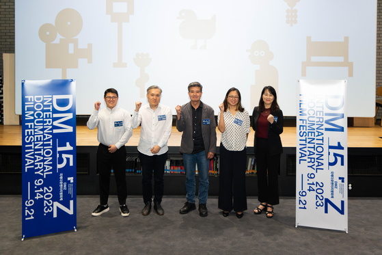 Organizers including the festival director Jang Hae-rang, center, pose for a photo during a press conference for the 15th DMZ International Documentary Film Festival at CGV Myeongdong Cine Library in Jung District, central Seoul, on Tuesday. [DMZ DOCS]