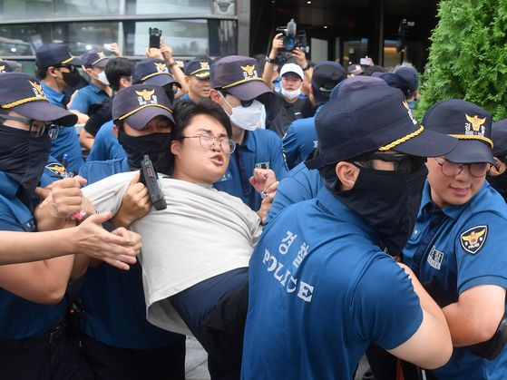 Police on Thursday apprehend a university student who attempted to break into the Japanese Embassy in central Seoul to protest Japan's discharge of the treated radioactive water from the ruined Fukushima Daiichi nuclear power plant. [YONHAP] 