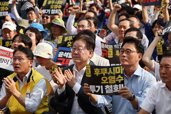 Democratic Party leader Jae-myung claps his hands during a rally against Japan's ongoing release of radioactive water from the Fukushima nuclear power plant. [YONHAP]
